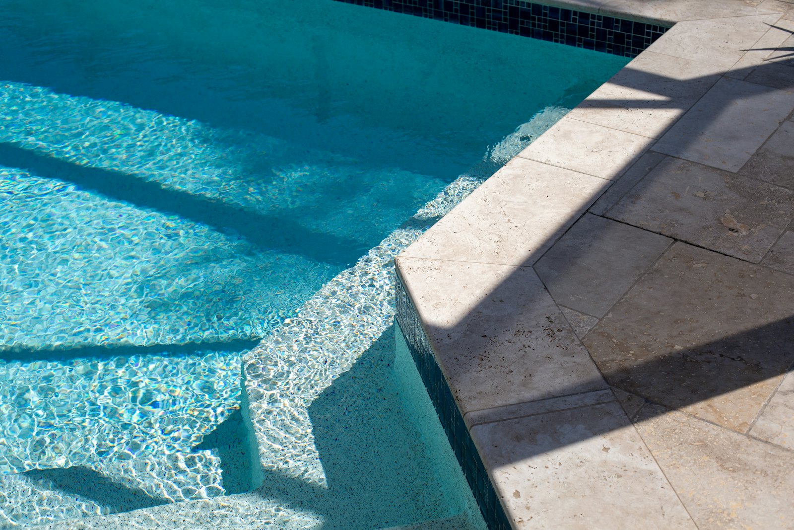 Empty swimming pool showing waterline tile and steps